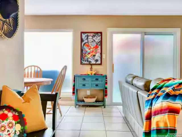 a dining room with furniture and a painting on the wall