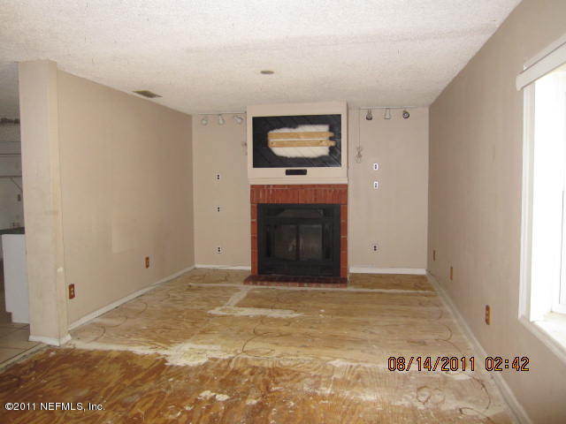 1360 Prince Road St. Augustine, FL 32086 - Photo 4 of 8 a view of an empty room with a fireplace and a window