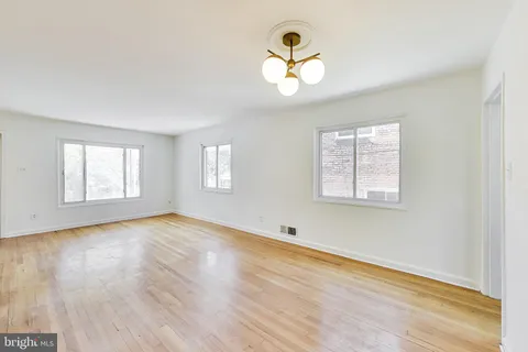 a kitchen with stainless steel appliances white cabinets and wooden floor