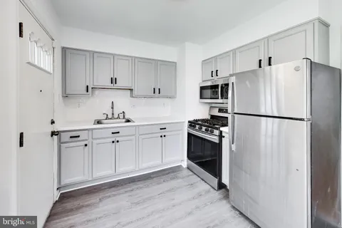 a kitchen with a stove a refrigerator and a window