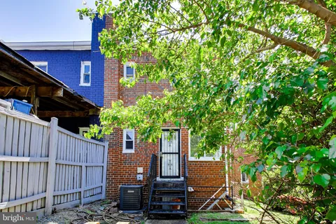 a view of a backyard with potted plants and large tree