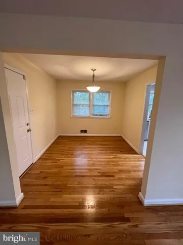 a view of empty room with wooden floor and fireplace