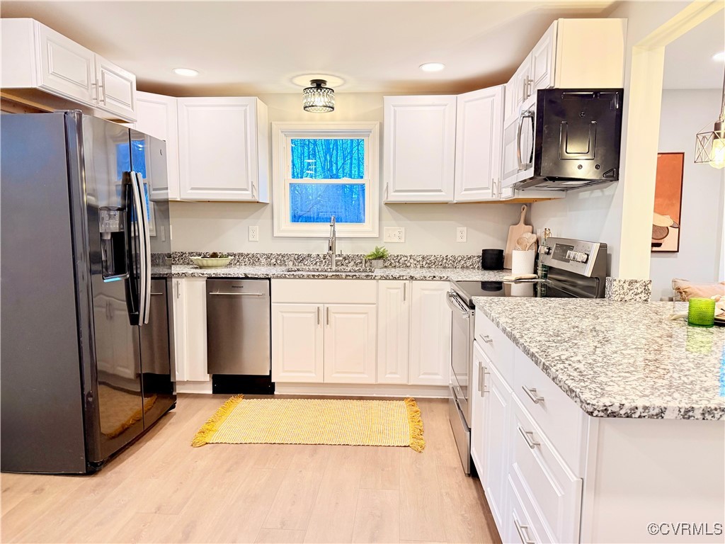 12410 Baltimore Road Ford, VA 23850 - Photo 6 of 11 a kitchen with stainless steel appliances granite countertop a sink stove refrigerator and microwave with wooden floor