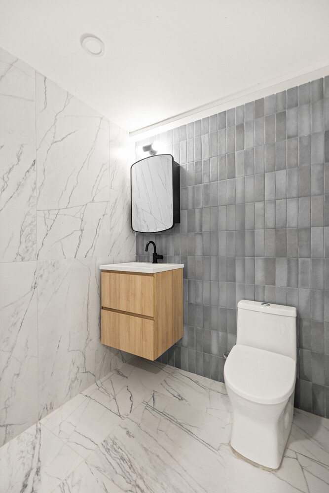 696 Chauncey Street, Unit 1R Brooklyn, NY 11207 - Photo 10 of 13 a bathroom with a toilet a sink and mirror