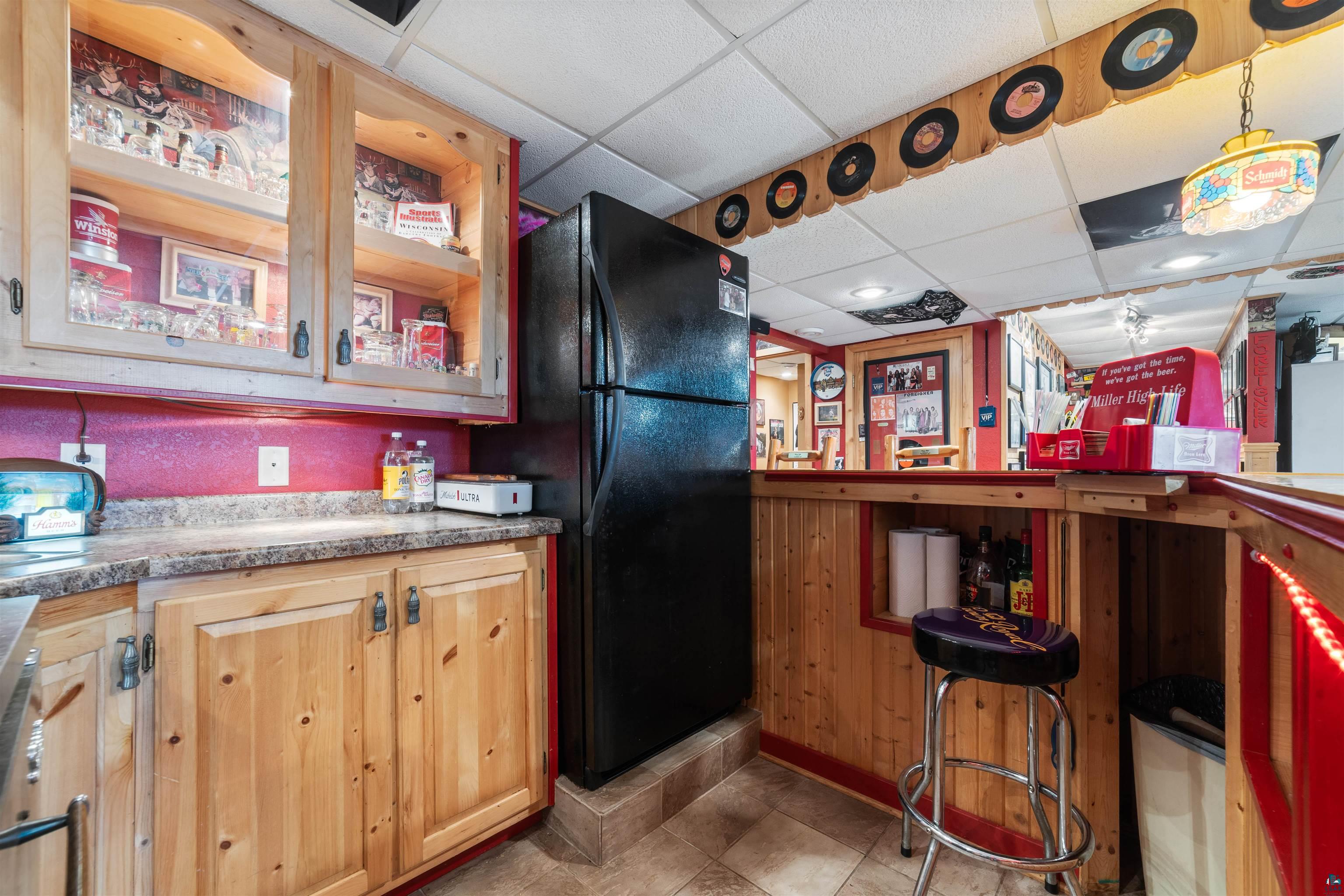 11911 East Rowe Road Lake Nebagamon, WI 54849 - Photo 59 of 61 Entertainment area featuring a built-in bar with wood paneling and a dedicated refrigerator