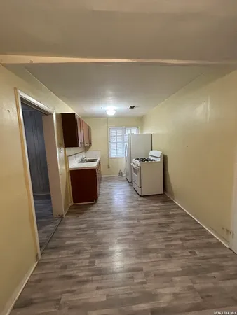 a room with a flat screen tv and kitchen view
