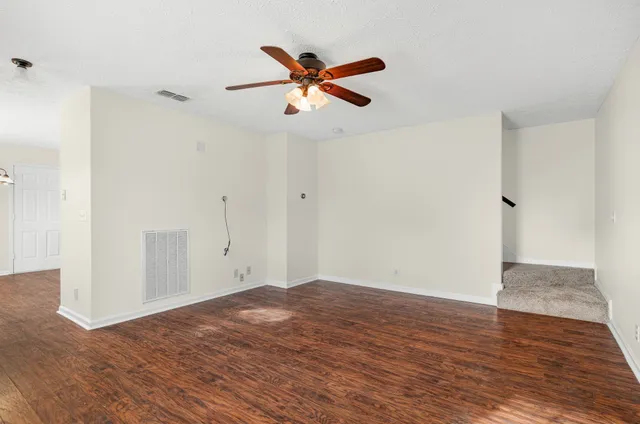 a view of empty room with wooden floor