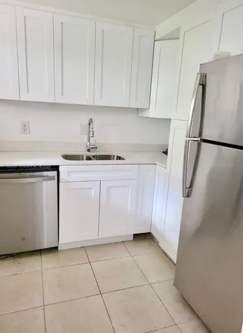 a kitchen with a sink a refrigerator and cabinets