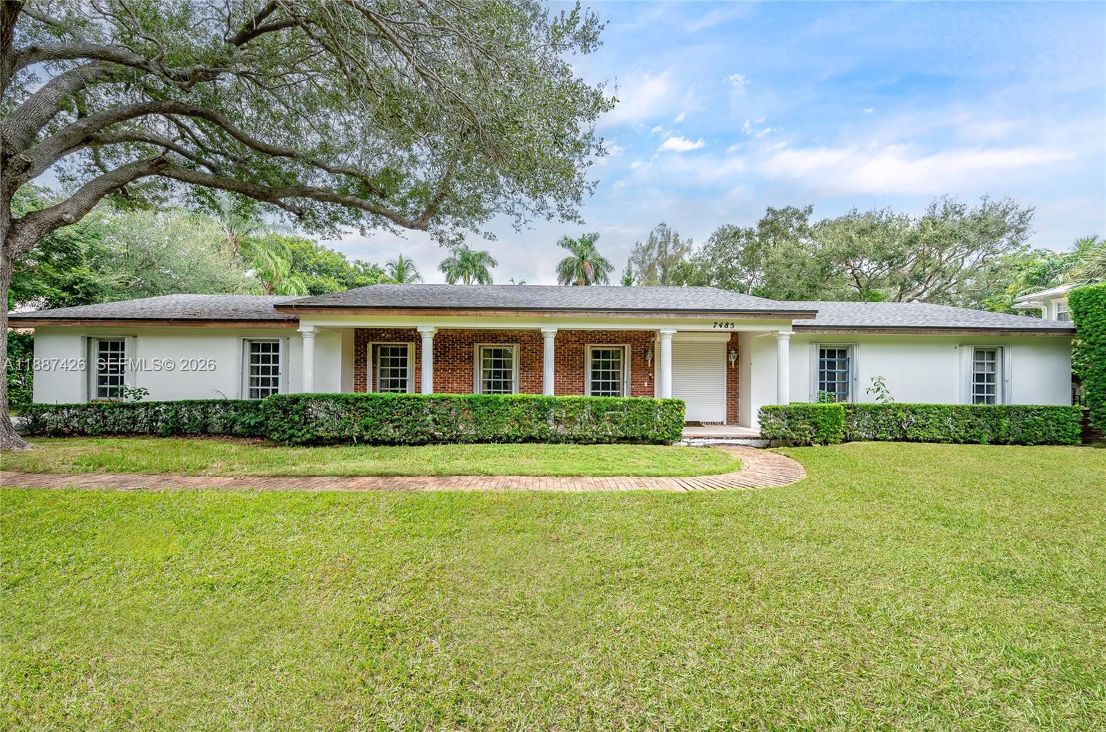 7485 Southwest 122nd Street Pinecrest, FL 33156 - Photo 4 of 12 a front view of house with yard and green space