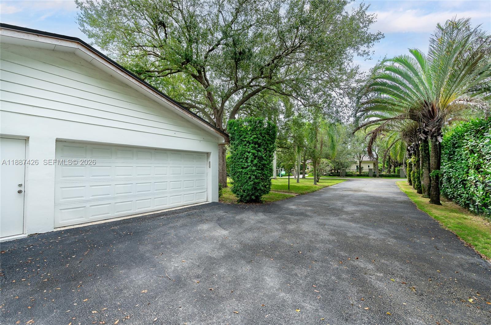 7485 Southwest 122nd Street Pinecrest, FL 33156 - Photo 7 of 12 a view of a house with a yard and garage