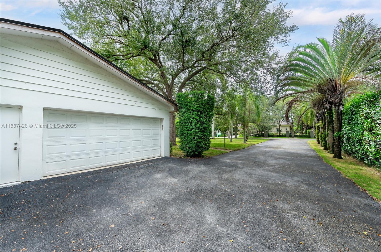 7485 Southwest 122nd Street Pinecrest, FL 33156 - Photo 7 of 12 a view of a house with a yard and garage