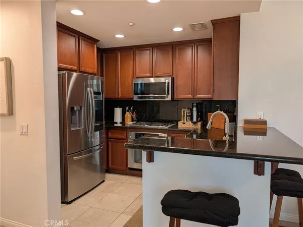 a kitchen with granite countertop a stove top oven microwave and cabinets