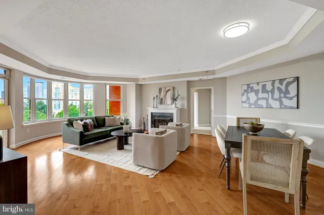 a living room with furniture a large window and potted plants