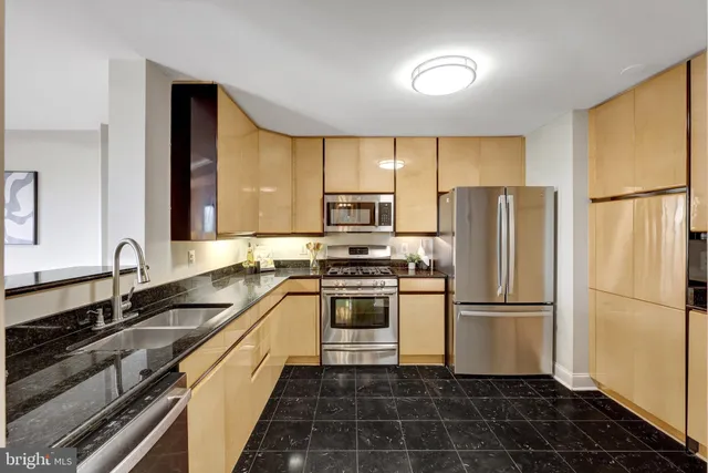 a kitchen with granite countertop a stove a sink and a microwave