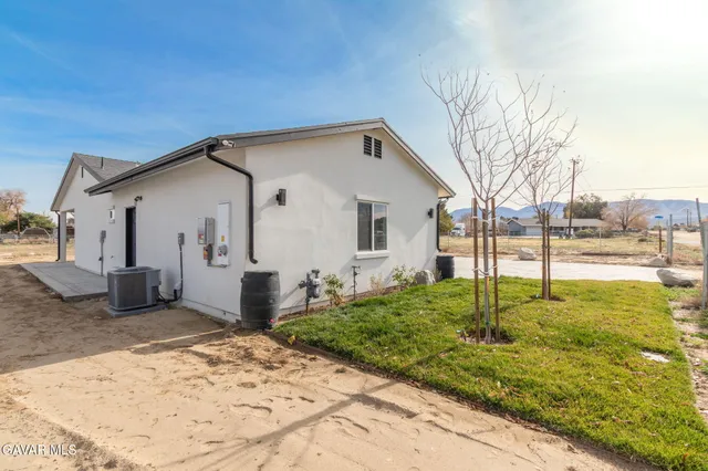 a backyard of a house with table and chairs