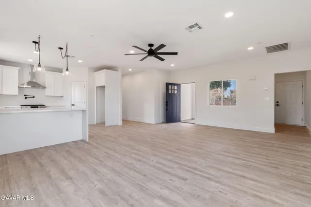 a view of an empty room and kitchen view