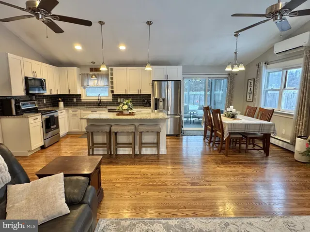 a living room with stainless steel appliances kitchen island granite countertop furniture and a view of kitchen