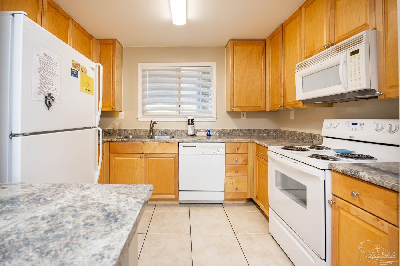 16470 Perdido Key Drive, Unit B13 Perdido Key, FL 32507 - Photo 10 of 17 a kitchen with a sink a stove top oven and cabinets