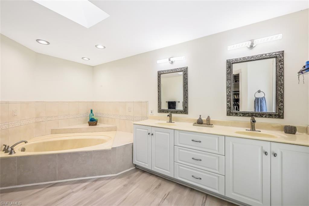2016 Duke Drive Naples, FL 34110 - Photo 13 of 23 a spacious bathroom with a double vanity sink mirror and bathtub
