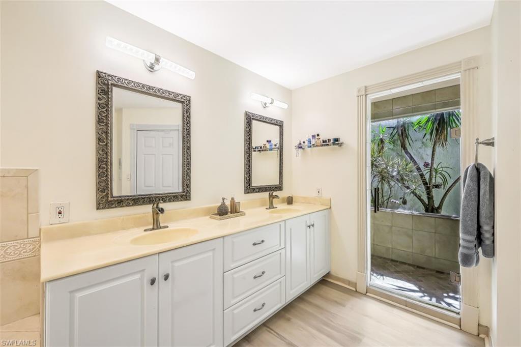 2016 Duke Drive Naples, FL 34110 - Photo 14 of 23 a spacious bathroom with a double vanity sink a mirror and a shower