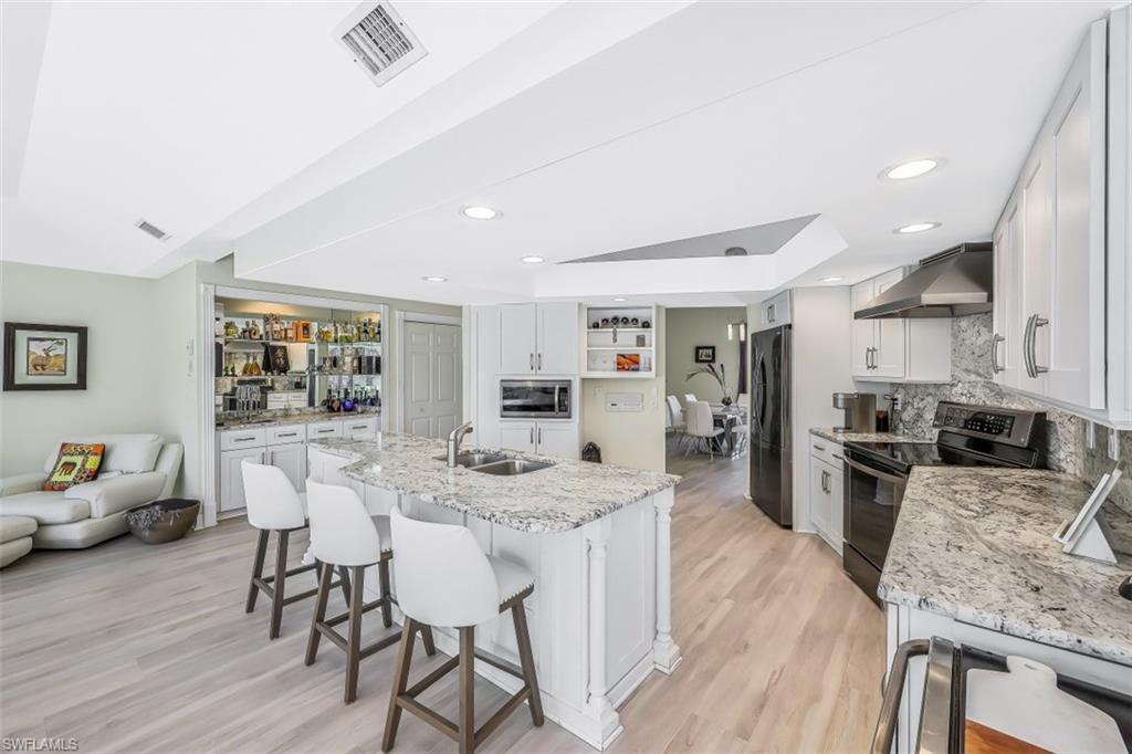 2016 Duke Drive Naples, FL 34110 - Photo 6 of 23 a kitchen with stainless steel appliances granite countertop sink stove refrigerator dining table and chairs