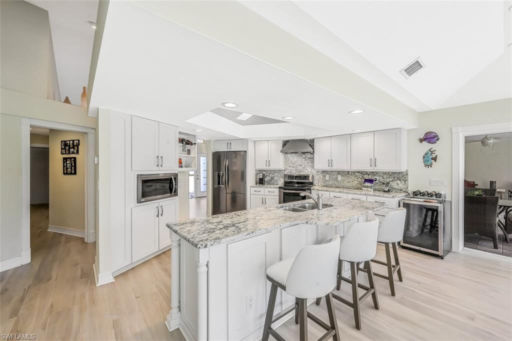 2016 Duke Drive Naples, FL 34110 - Photo 7 of 23 a kitchen with stainless steel appliances kitchen island granite countertop a refrigerator and a stove top oven