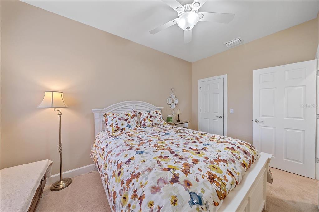 17535 Hampton Falls Terrace Bradenton, FL 34202 - Photo 13 of 41 a bedroom with a large bed and a chandelier