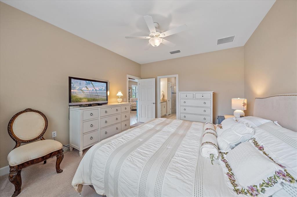 17535 Hampton Falls Terrace Bradenton, FL 34202 - Photo 24 of 41 a bedroom with a bed and a dresser with chair