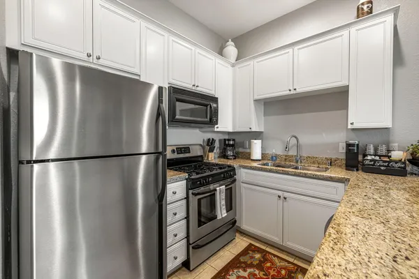 a kitchen with stainless steel appliances a refrigerator a stove a sink and cabinets