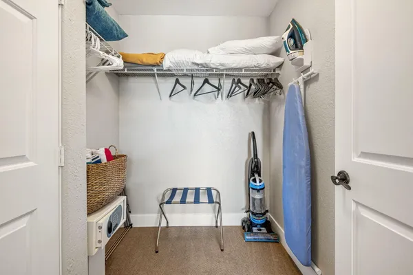 a view of walk in closet with clothes and shoes