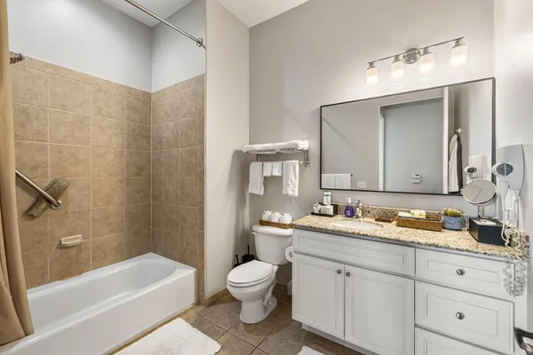 a bathroom with a double vanity sink toilet mirror and bathtub