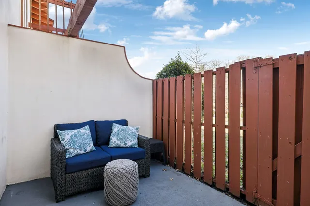 a blue couch sitting next to a wooden fence