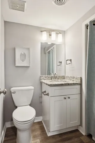 a bathroom with a toilet a sink and mirror