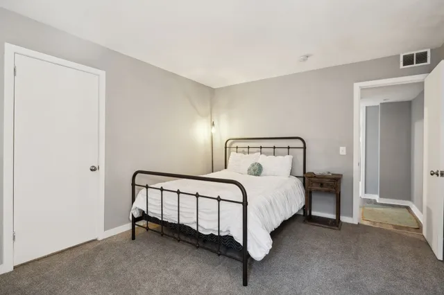 a view of a bedroom with a bed and a window