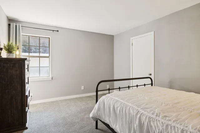 a large bed sitting in a bedroom next to a window