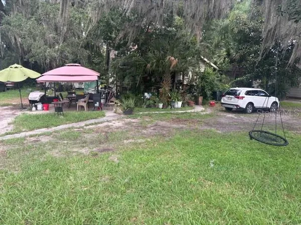 a backyard of a house with table and chairs