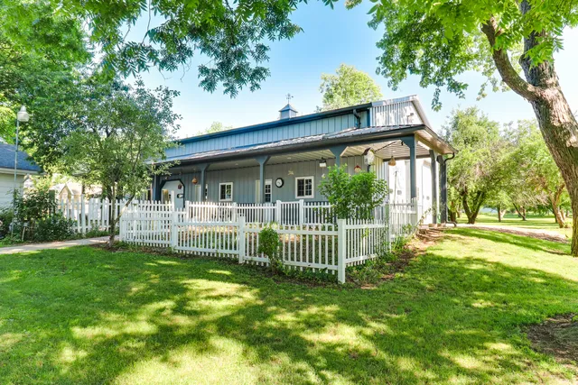 a view of a house with a small yard and a large tree