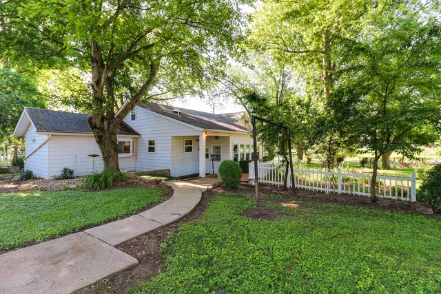 a front view of a house with yard and green space