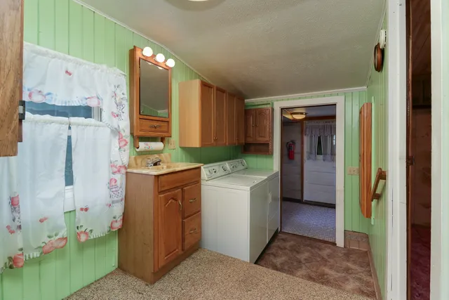 a kitchen with stainless steel appliances granite countertop a sink a stove a refrigerator cabinets and chairs