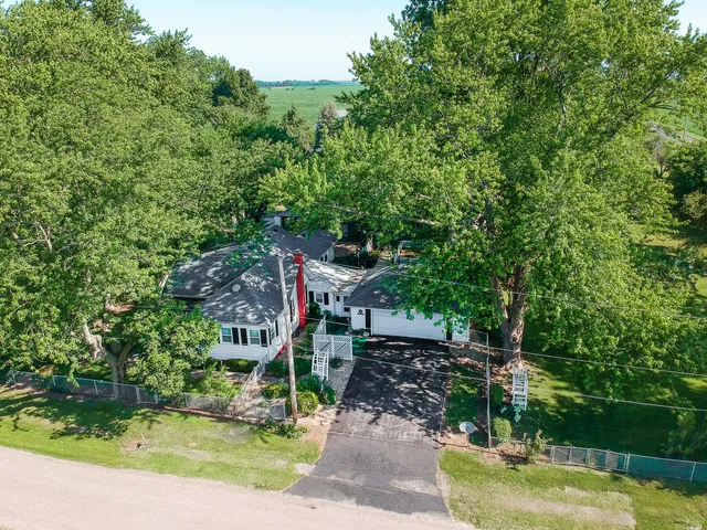 a view of a house with a yard and large tree