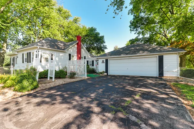 an aerial view of residential house with outdoor space and trees all around