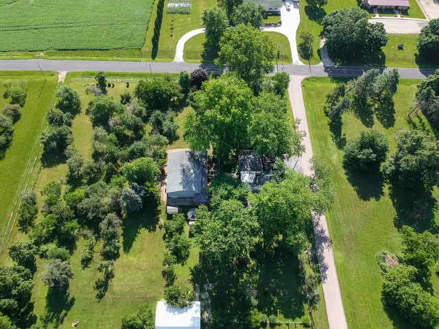 an aerial view of residential house with outdoor space and trees all around