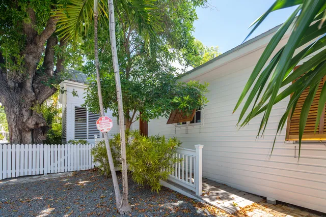 a view of a house with a small yard and wooden fence