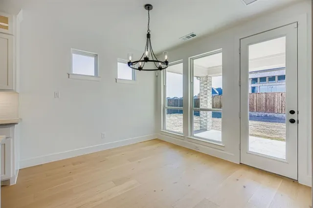 a view of a room with cabinet wooden floor and a chandelier