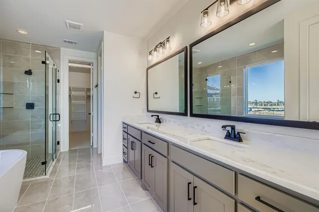 a bathroom with a double vanity sink mirror and shower
