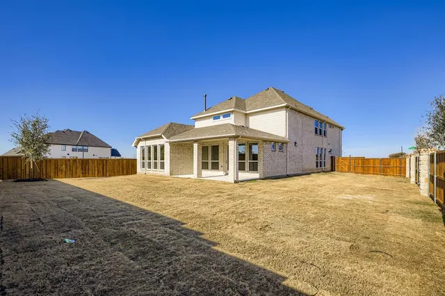 a front view of house with yard and trees in the background