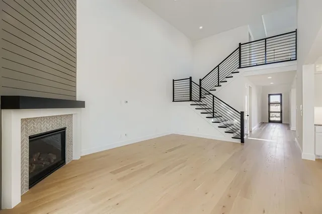 a view of a livingroom with wooden floor and a fireplace