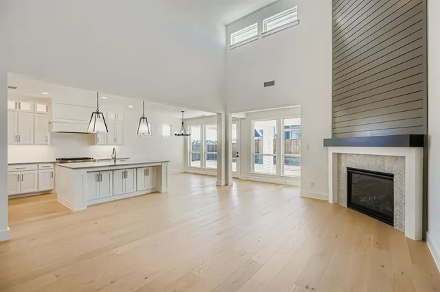 a large white kitchen with granite countertop a stove top oven a sink and dishwasher