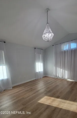 a view of wooden floor and windows in a room