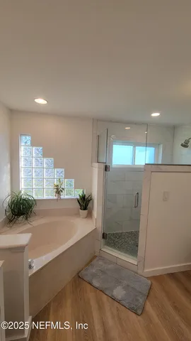 a view of a bathroom with a tub and shower